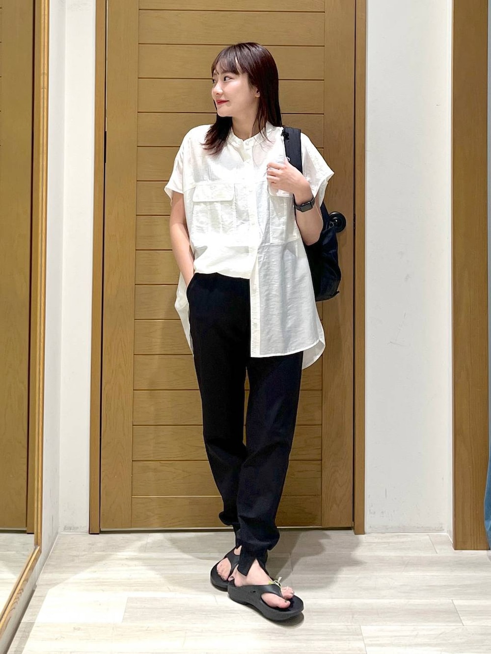 ブラック系のその他パンツ、ホワイト系のシャツ/ブラウス、ブラック系のサンダルを着用したレディースの夏コーディネートの3枚目の写真