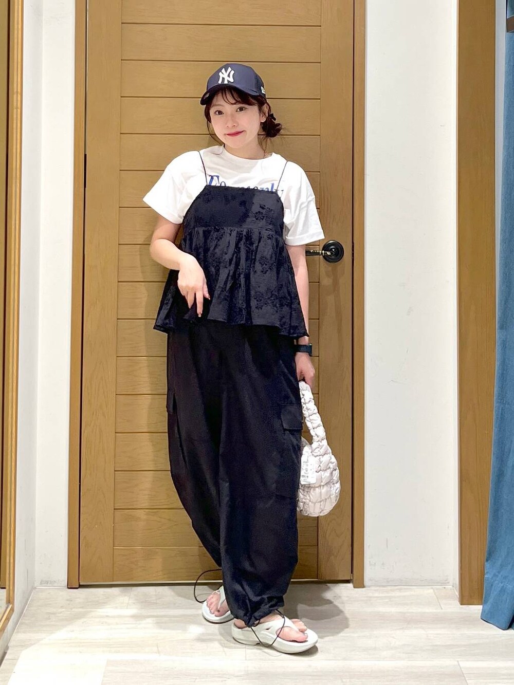 ホワイト系のTシャツ/カットソー、ブラック系のその他パンツ、グレー系のサンダルを着用したレディースの夏コーディネートの2枚目の写真