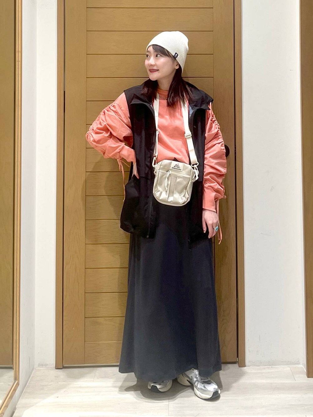 ブラック系のベスト、ベージュ系のショルダーバッグ、ピンク系のTシャツ/カットソーを着用したレディースの春コーディネートの4枚目の写真