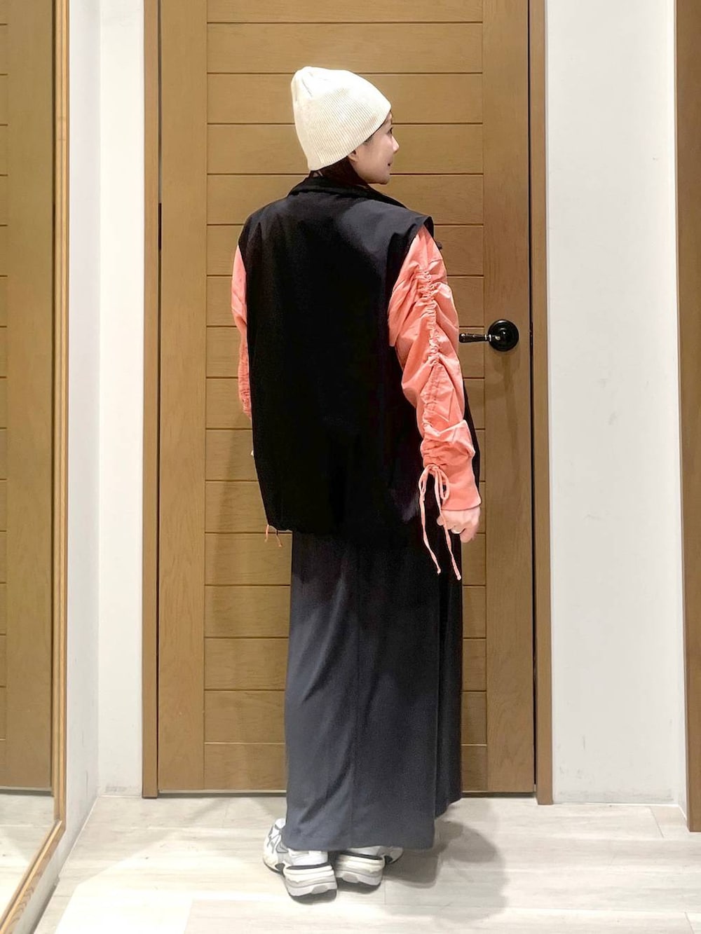 ブラック系のベスト、ベージュ系のショルダーバッグ、ピンク系のTシャツ/カットソーを着用したレディースの春コーディネートの3枚目の写真