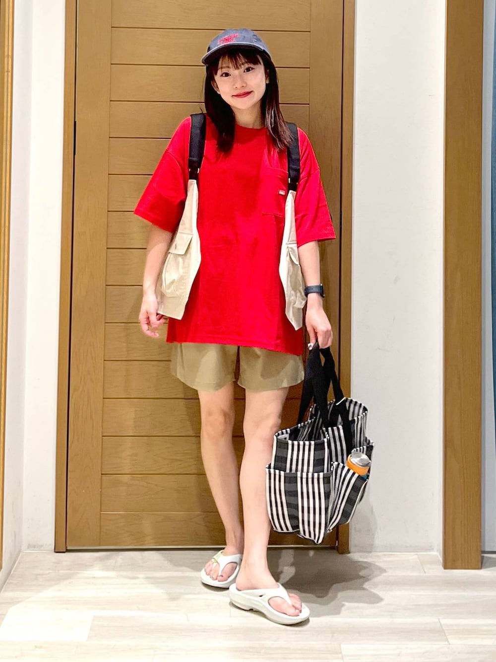 グリーン系のその他パンツ、ブラック系のトートバッグ、レッド系のTシャツ/カットソーを着用したレディースの夏コーディネートの6枚目の写真