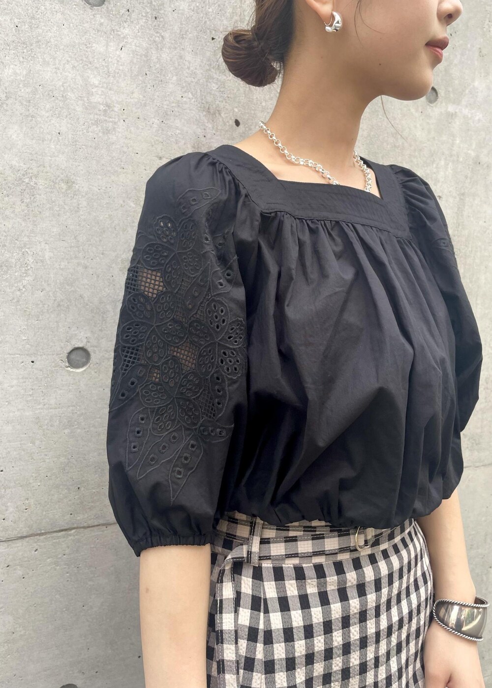 ブラック系のサンダル、ブラック系のスカート、ブラック系のシャツ/ブラウスを着用したレディースの春コーディネートの3枚目の写真