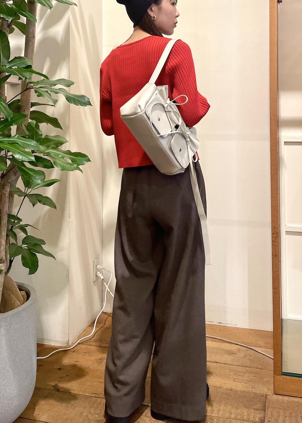 ブラック系のキャミソール、ブラック系のブーツ、レッド系のカーディガン/ボレロを着用したレディースの秋コーディネートの3枚目の写真