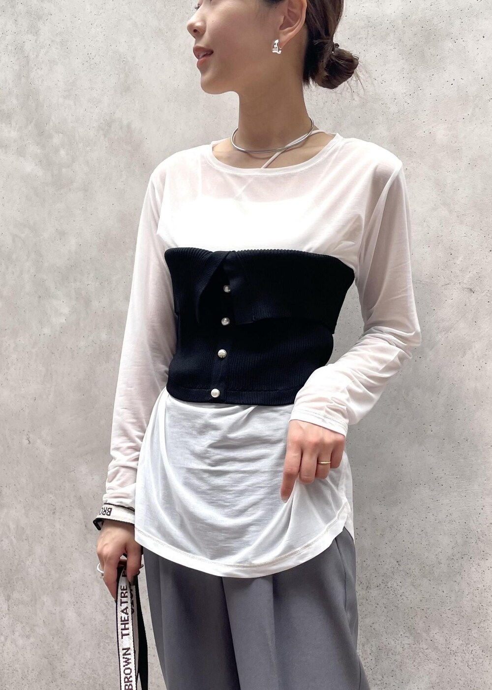 グレー系のスラックス、ホワイト系のTシャツ/カットソー、ホワイト系のショルダーバッグを着用したレディースの夏コーディネートの3枚目の写真