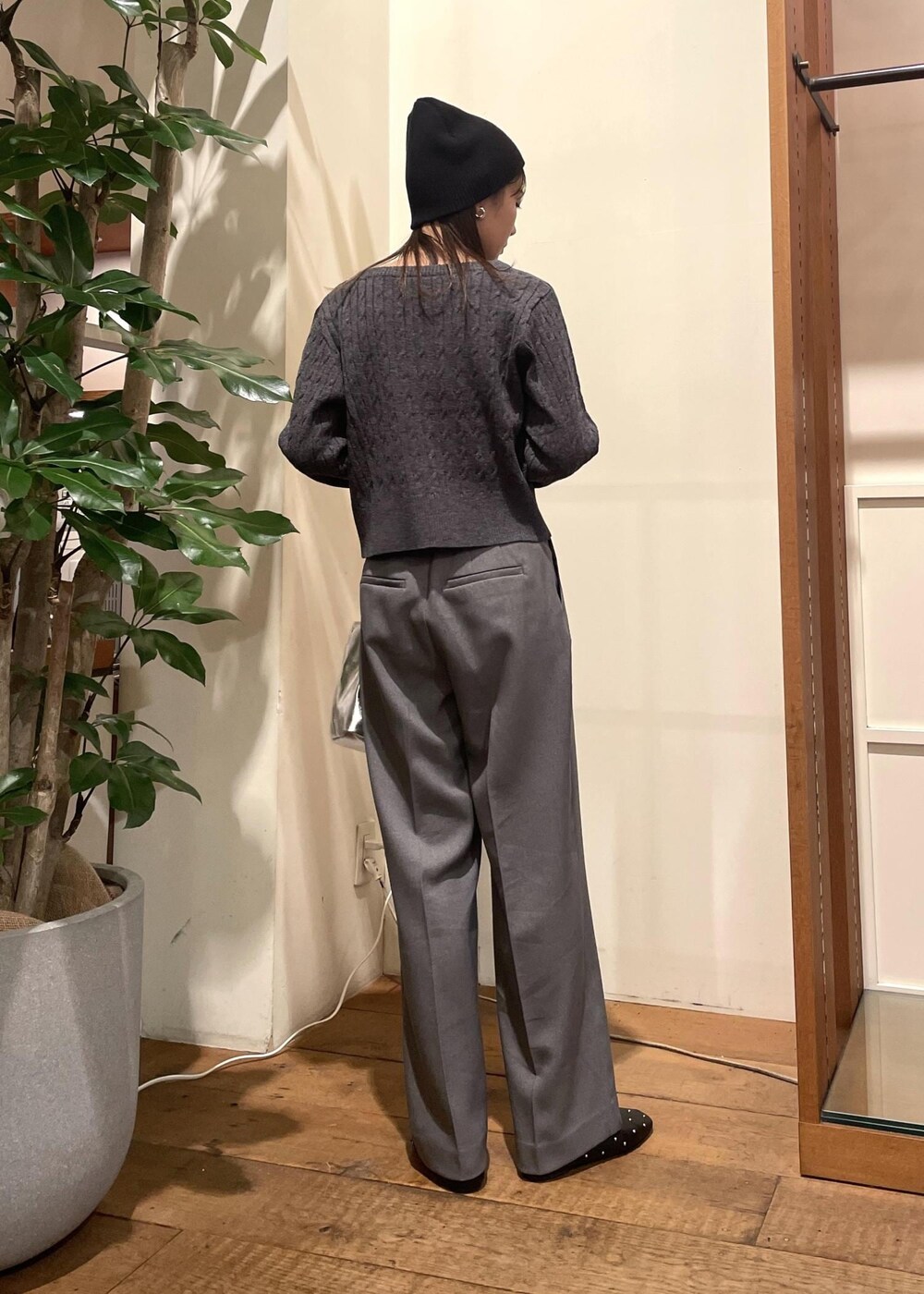 シルバー系のショルダーバッグ、ブラック系のバレエシューズ、グレー系のスラックスを着用したレディースの冬コーディネートの2枚目の写真