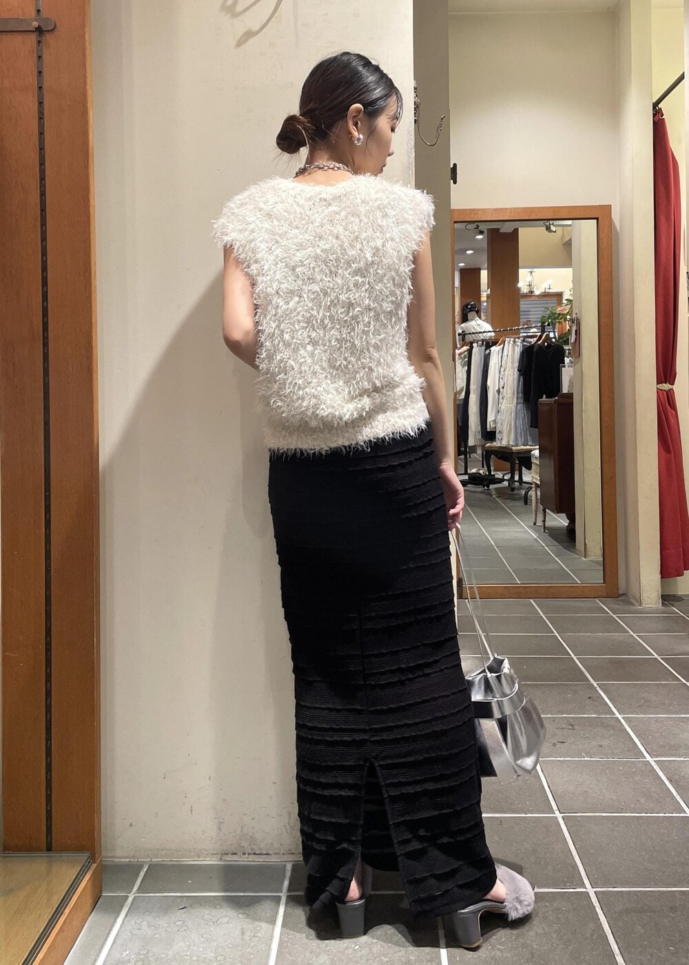 ブラック系のスカート、ブラック系のキャミソール、ホワイト系のベストを着用したレディースの夏コーディネートの3枚目の写真