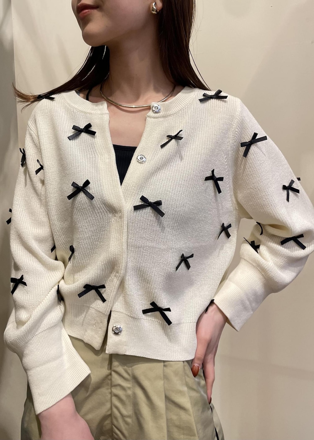 ベージュ系のスラックス、シルバー系のショルダーバッグ、シルバー系のパンプスを着用したレディースの春コーディネートの3枚目の写真