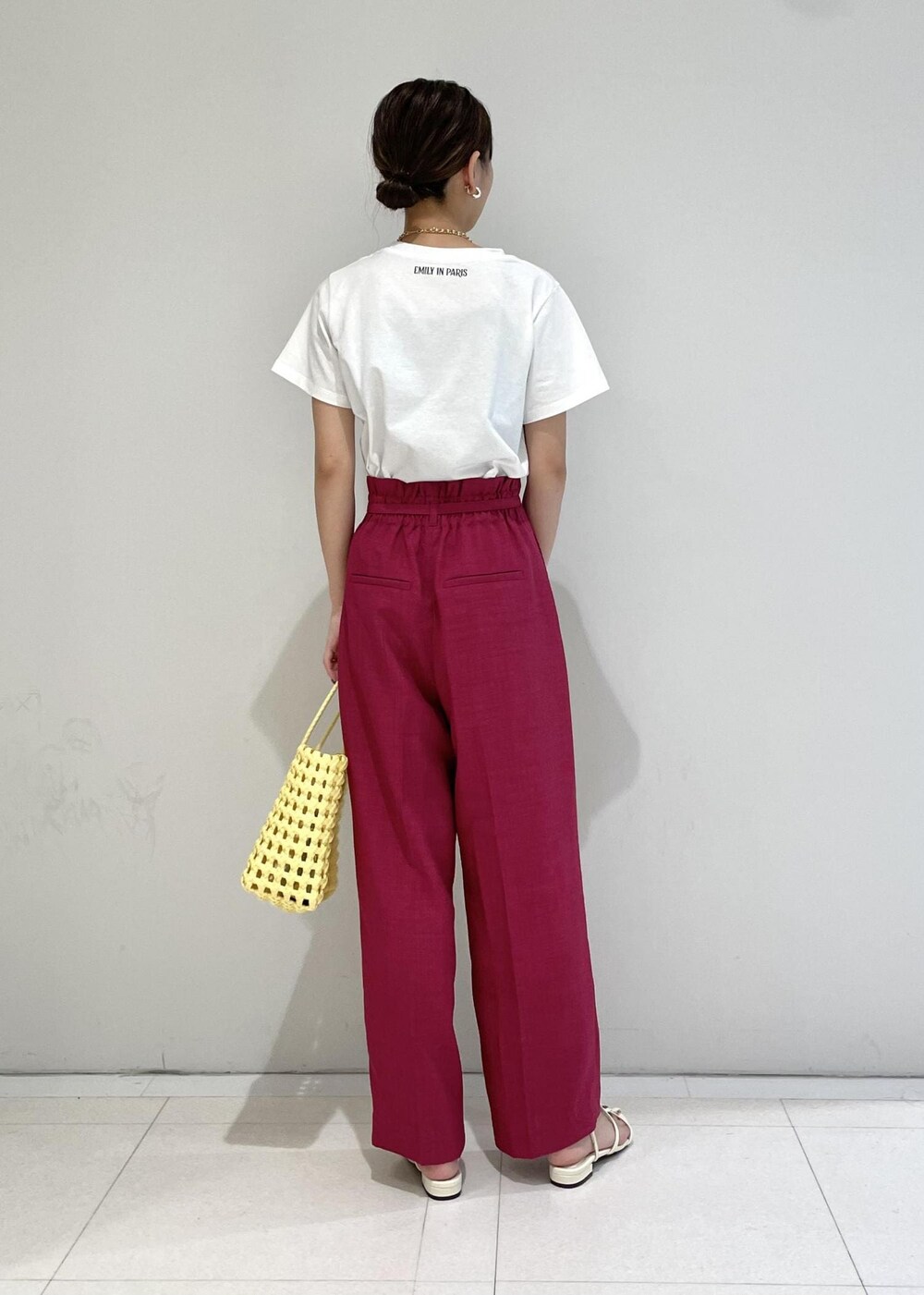 ピンク系のスラックス、ホワイト系のサンダル、ホワイト系のTシャツ/カットソーを着用したレディースの夏コーディネートの3枚目の写真