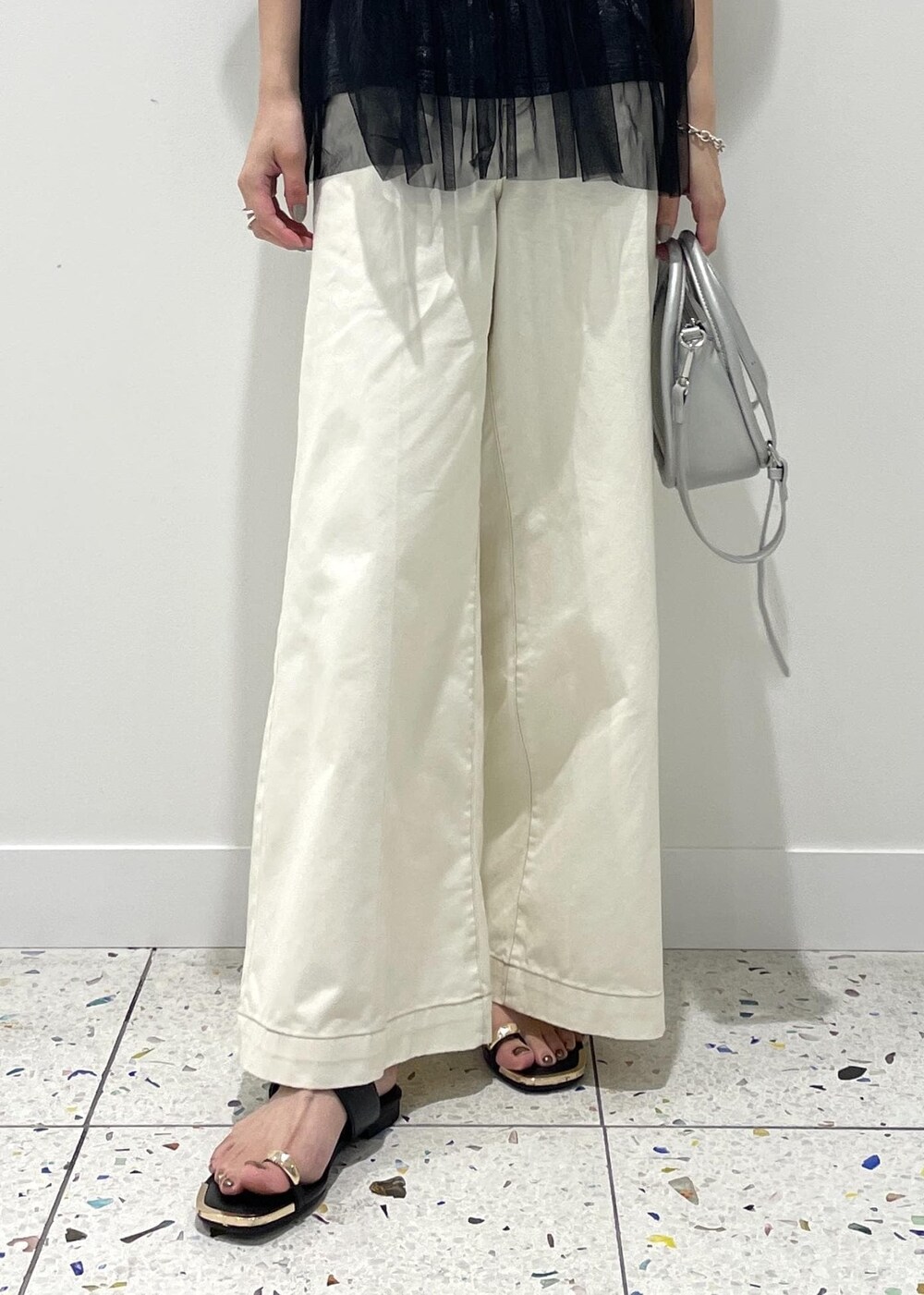 シルバー系のショルダーバッグ、ブラック系のサンダル、ブラック系のTシャツ/カットソーを着用したレディースの夏コーディネートの4枚目の写真