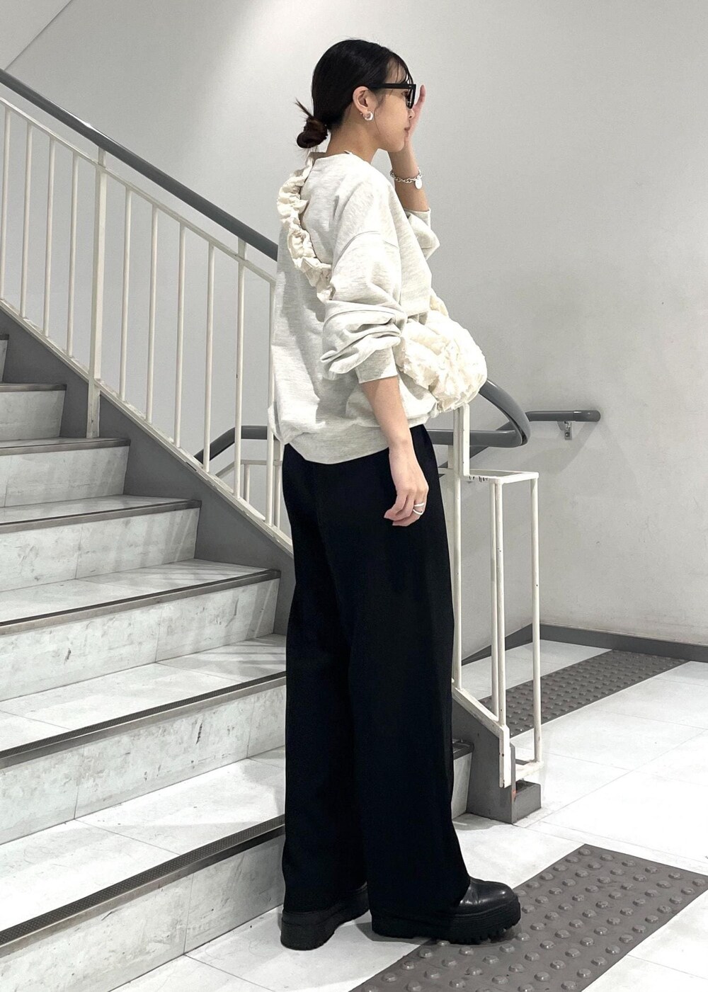 ブラック系のブーツ、ホワイト系のショルダーバッグ、ホワイト系のスウェットを着用したレディースの秋コーディネートの5枚目の写真