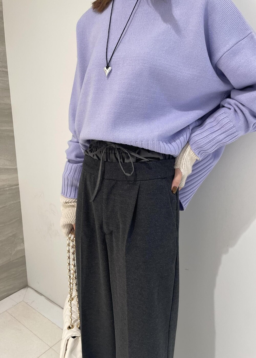 ホワイト系のショルダーバッグ、パープル系のニット/セーター、グレー系のスラックスを着用したレディースの秋コーディネートの4枚目の写真