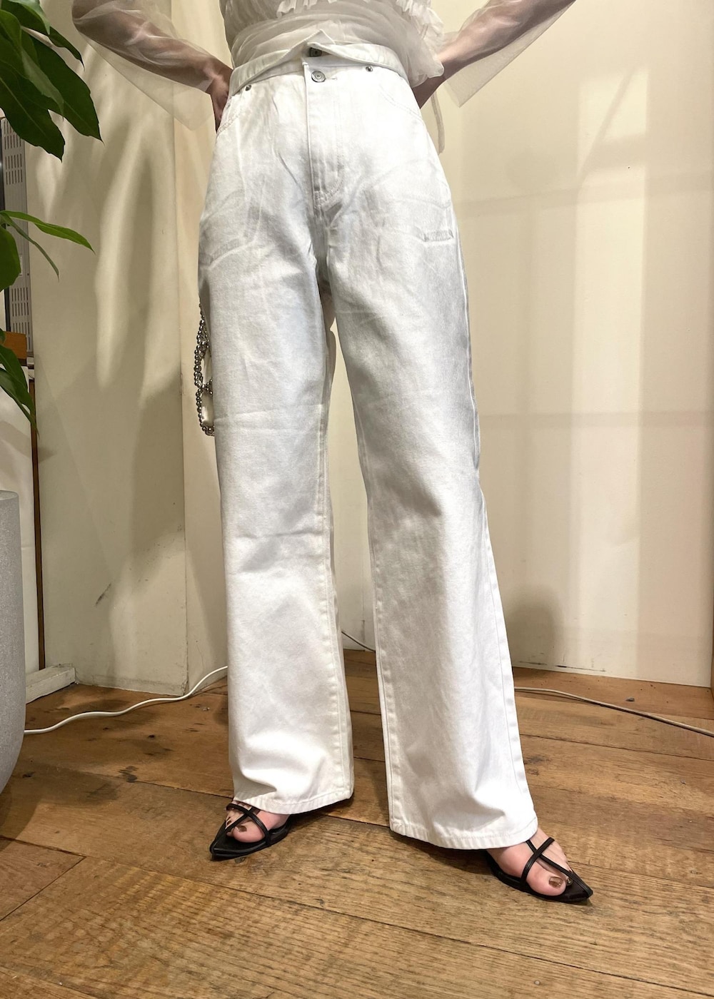 ホワイト系のデニムパンツ、シルバー系のハンドバッグ、ホワイト系のTシャツ/カットソーを着用したレディースの春コーディネートの3枚目の写真