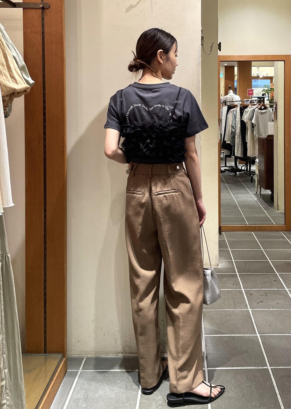 ブラック系のTシャツ/カットソー、ブラック系のキャミソール、ブラウン系のスラックスを着用したレディースの夏コーディネートの4枚目の写真