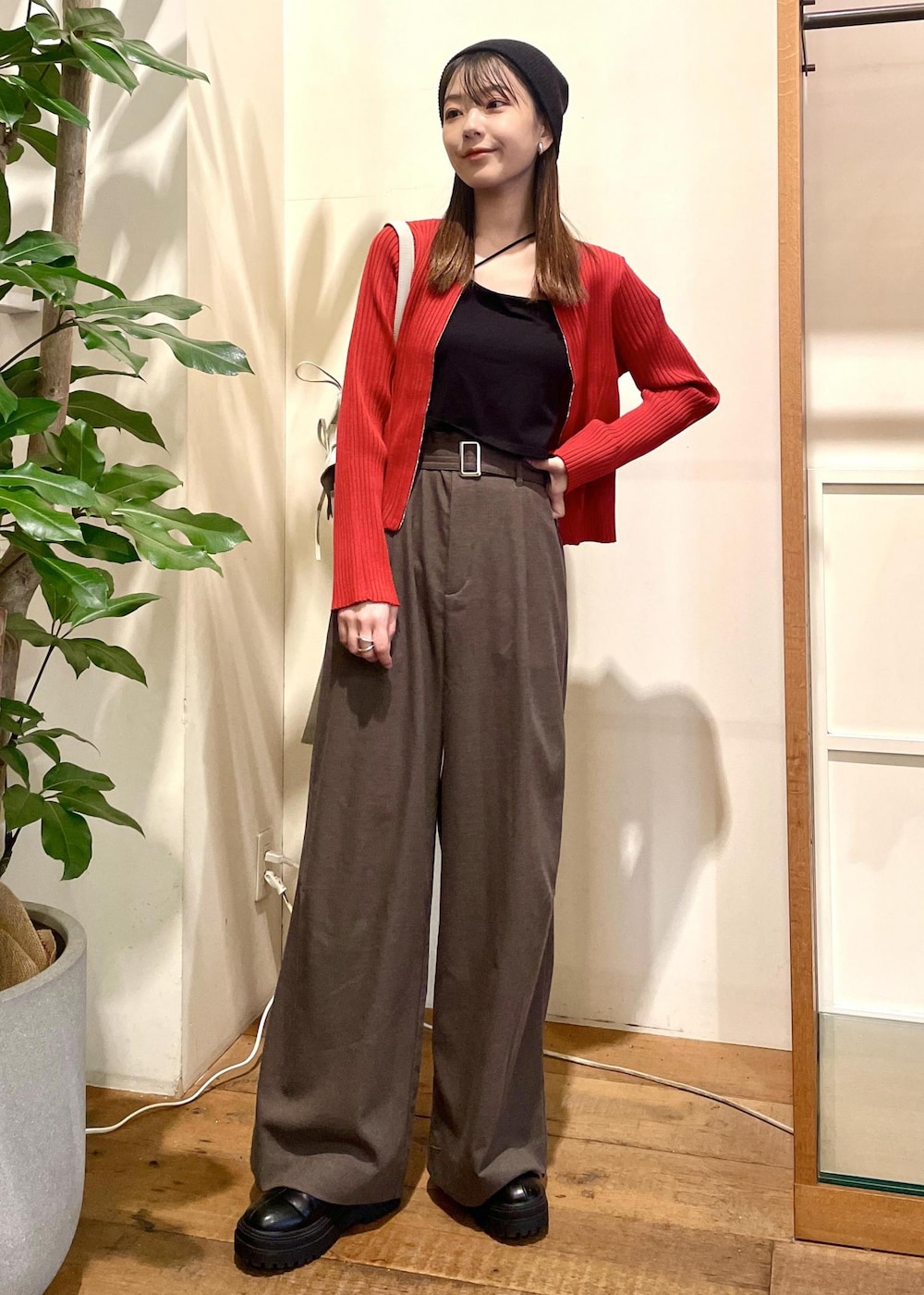 ブラック系のキャミソール、ブラック系のブーツ、レッド系のカーディガン/ボレロを着用したレディースの秋コーディネートの2枚目の写真