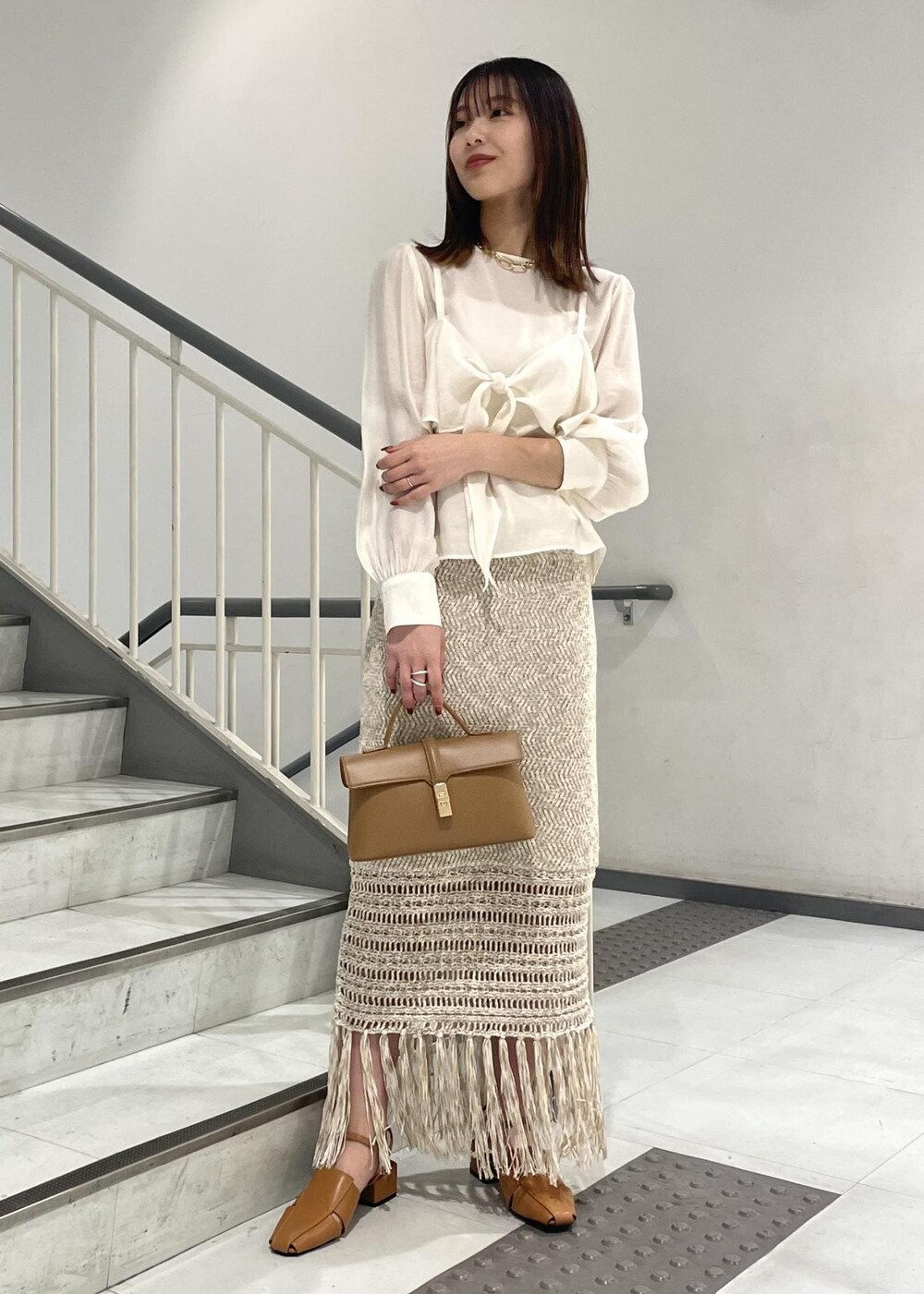 イエロー系のショルダーバッグ、イエロー系のサンダル、ホワイト系のシャツ/ブラウスを着用したレディースの春コーディネートの3枚目の写真