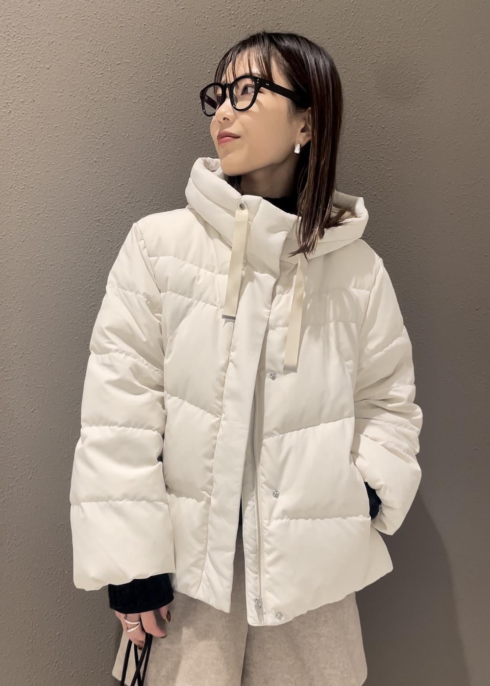 ブラウン系のブーツ、ホワイト系のダウンジャケット/コート、グレー系のニット/セーターを着用したレディースの冬コーディネートの3枚目の写真