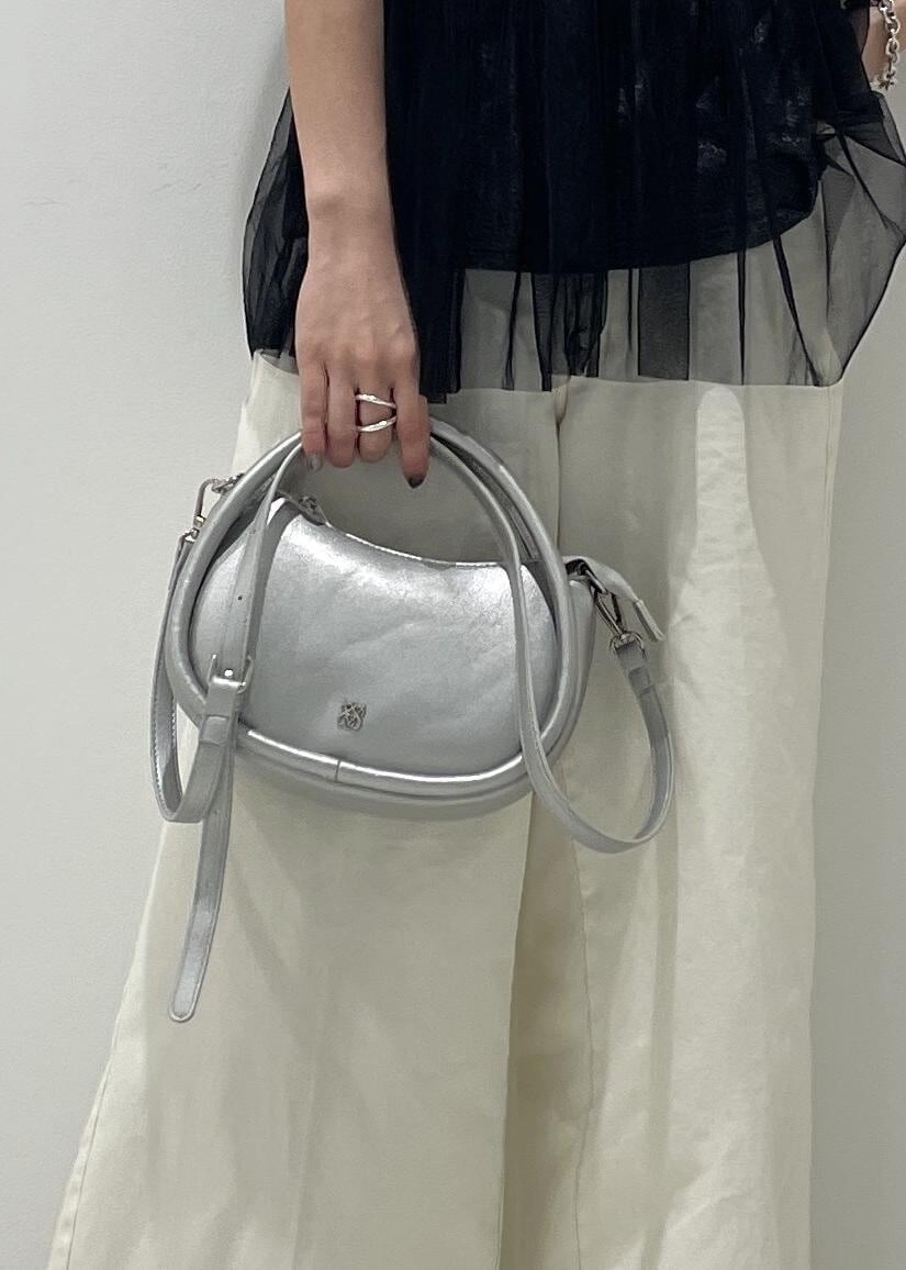 シルバー系のショルダーバッグ、ブラック系のサンダル、ブラック系のTシャツ/カットソーを着用したレディースの夏コーディネートの5枚目の写真