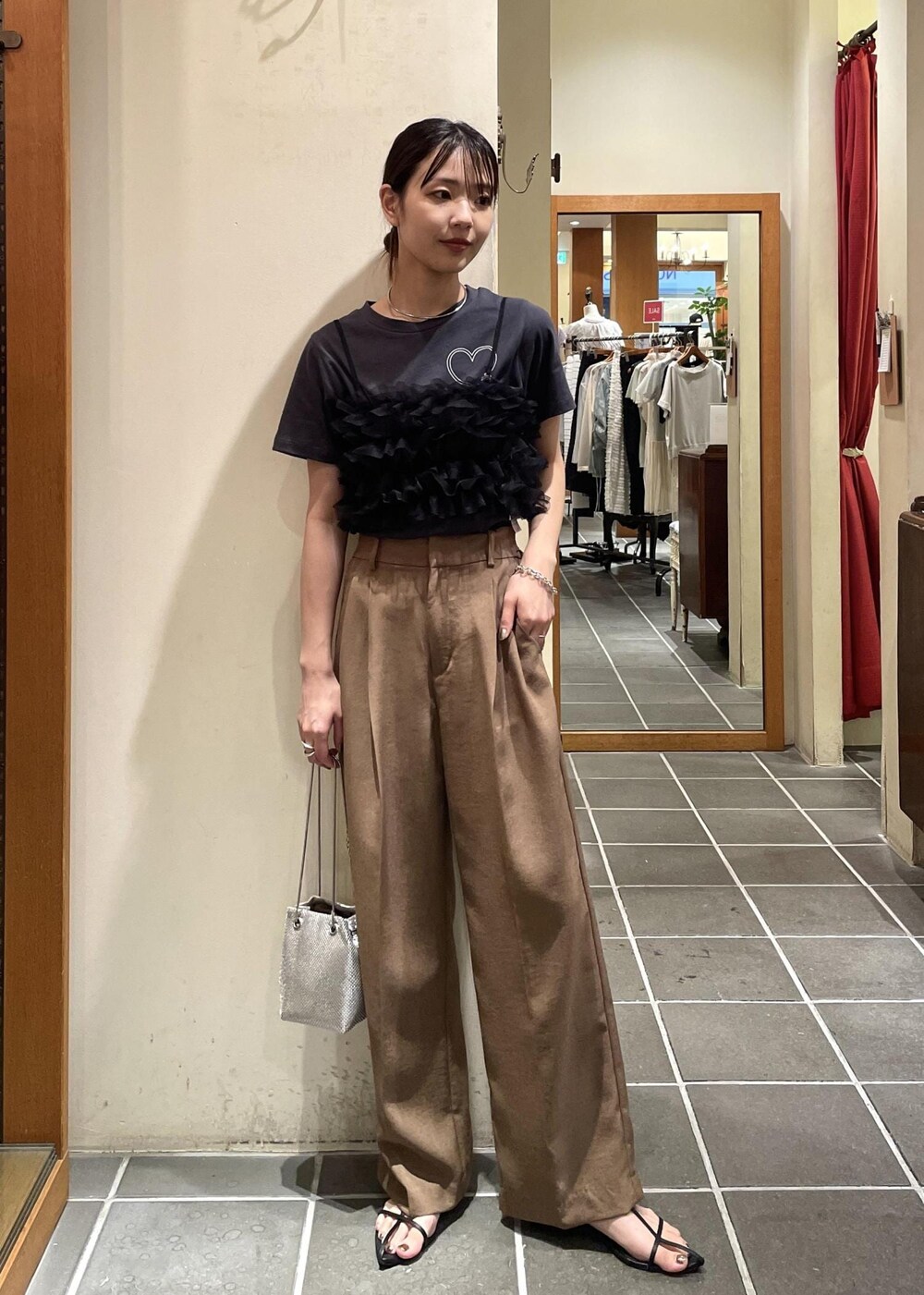 ブラック系のTシャツ/カットソー、ブラック系のキャミソール、ブラウン系のスラックスを着用したレディースの夏コーディネートの3枚目の写真