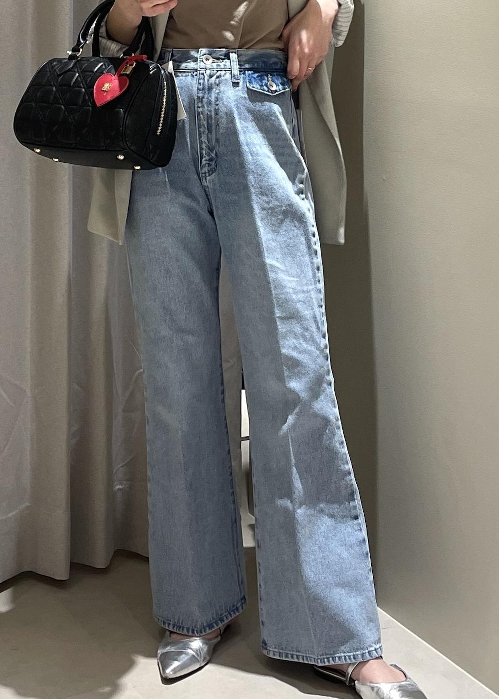 ベージュ系のキャミソール、グリーン系のテーラードジャケット、ブルー系のデニムパンツを着用したレディースの春コーディネートの7枚目の写真