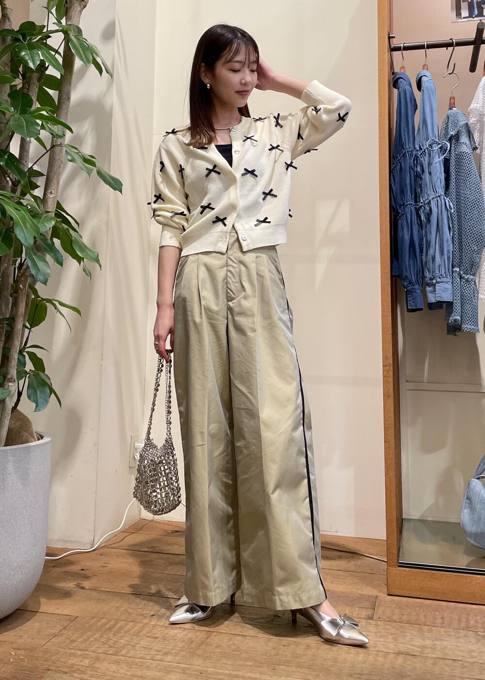 ベージュ系のスラックス、シルバー系のショルダーバッグ、シルバー系のパンプスを着用したレディースの春コーディネートの2枚目の写真