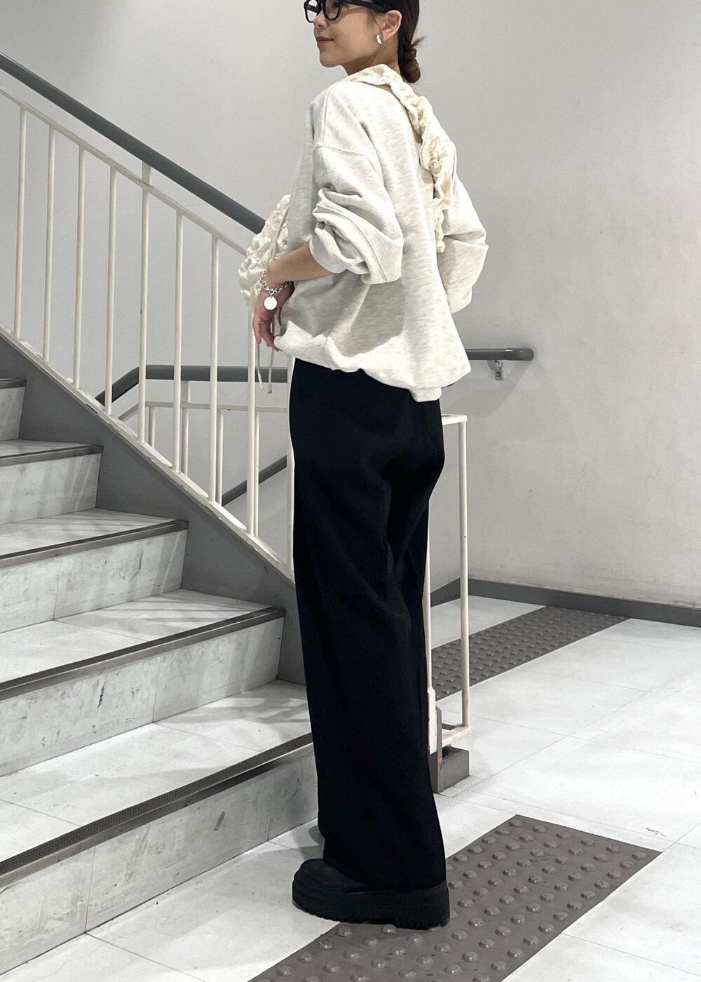 ブラック系のブーツ、ホワイト系のショルダーバッグ、ホワイト系のスウェットを着用したレディースの秋コーディネートの3枚目の写真