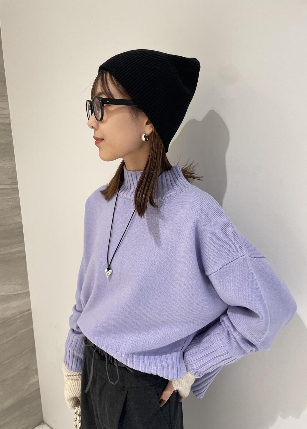 ホワイト系のショルダーバッグ、パープル系のニット/セーター、グレー系のスラックスを着用したレディースの秋コーディネートの5枚目の写真