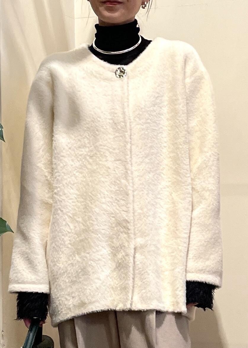 グリーン系のショルダーバッグ、ブラック系のブーツ、ブラック系のニット/セーターを着用したレディースの冬コーディネートの4枚目の写真