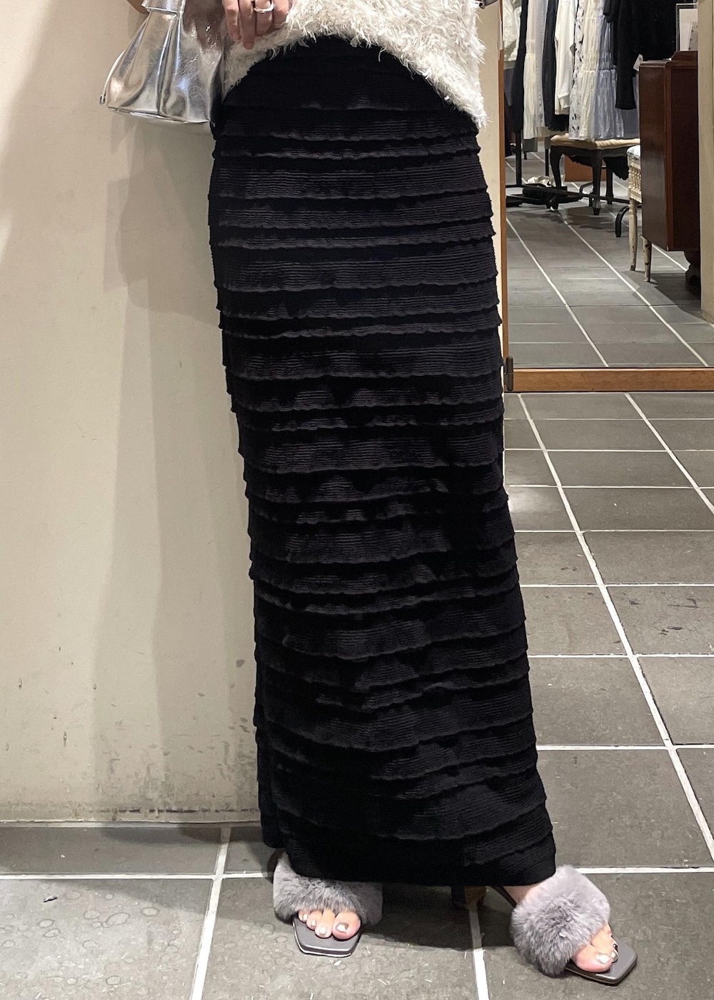 ブラック系のスカート、ブラック系のキャミソール、ホワイト系のベストを着用したレディースの夏コーディネートの4枚目の写真