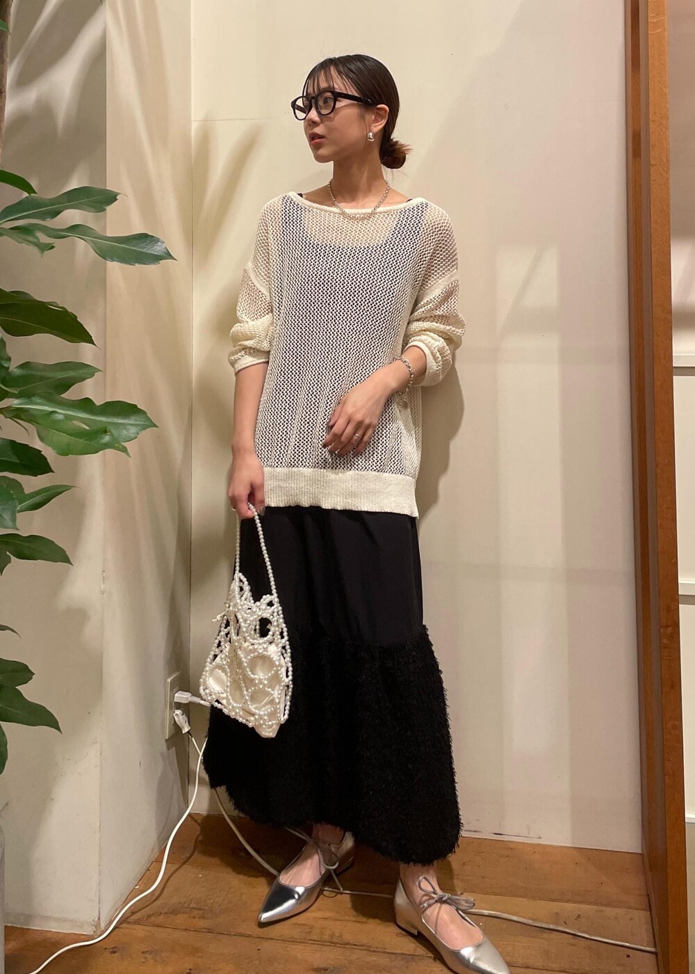 シルバー系のパンプス、ホワイト系のハンドバッグ、ホワイト系のニット/セーターを着用したレディースの夏コーディネートの2枚目の写真