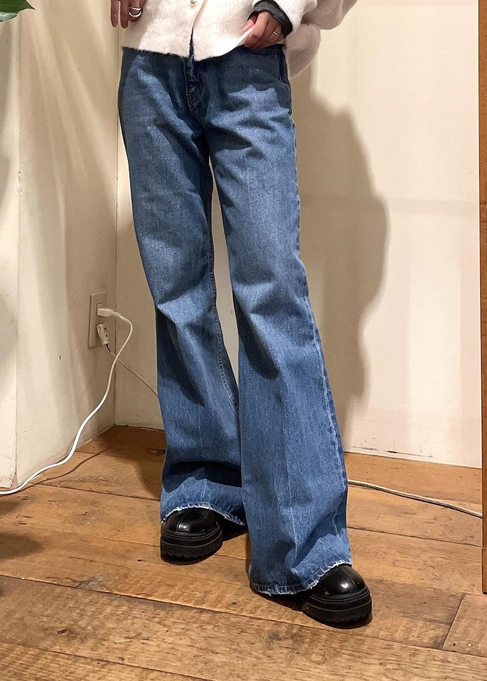 ブルー系のデニムパンツ、ブラック系のブーツ、ホワイト系のハンドバッグを着用したレディースの冬コーディネートの5枚目の写真