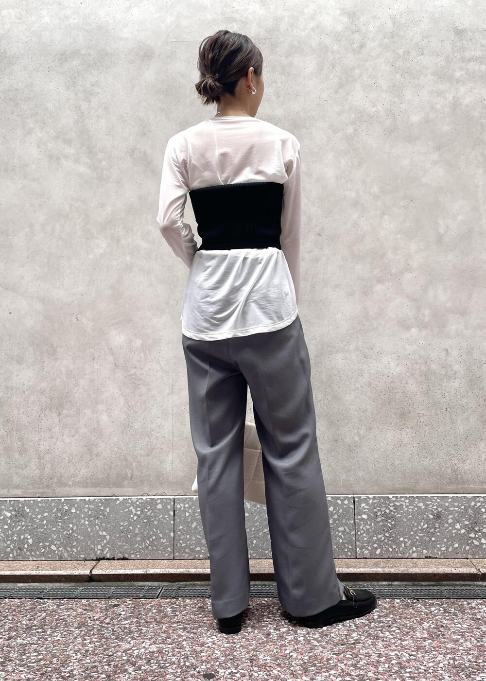 グレー系のスラックス、ホワイト系のTシャツ/カットソー、ホワイト系のショルダーバッグを着用したレディースの夏コーディネートの2枚目の写真