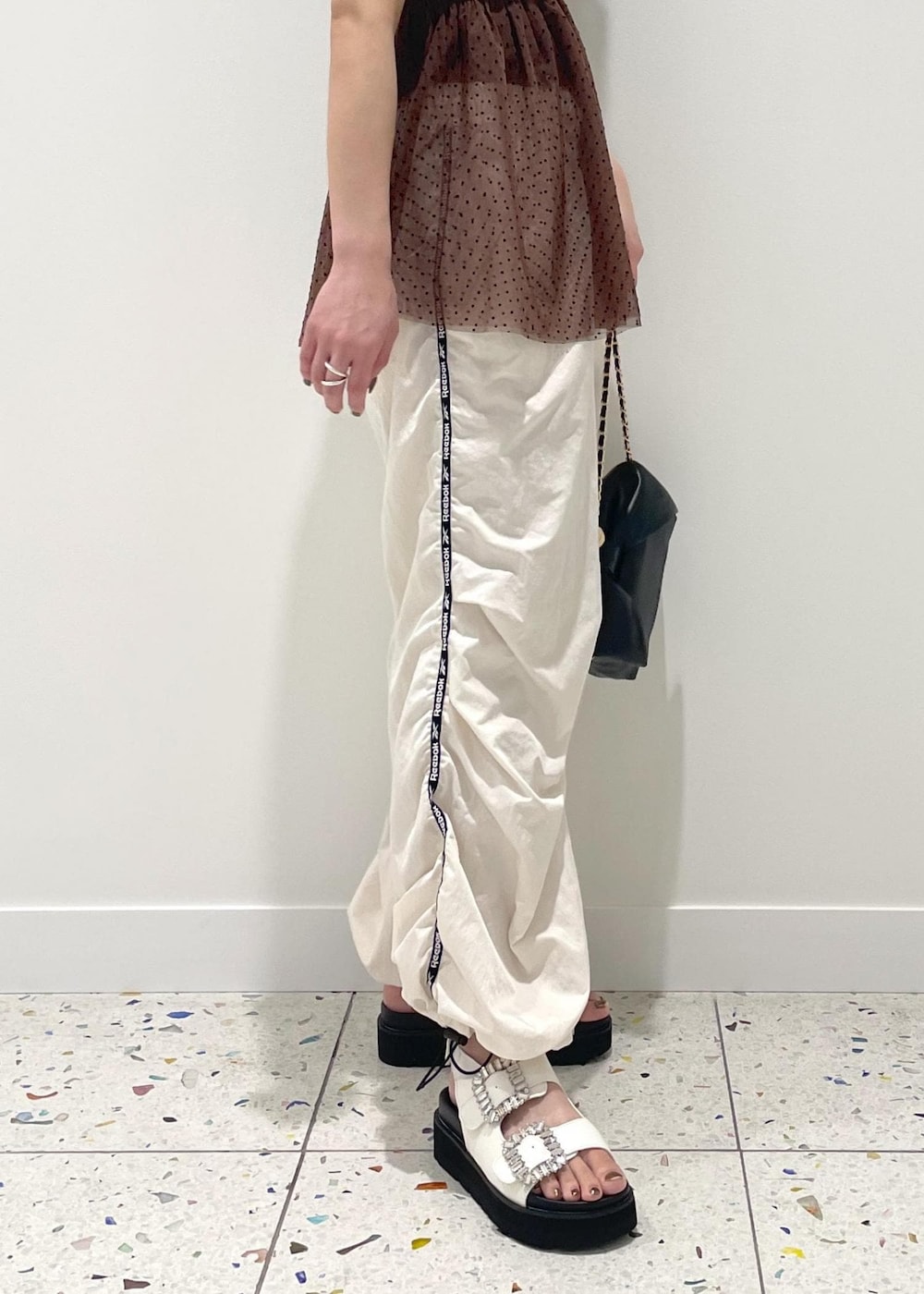 ブラック系のショルダーバッグ、ホワイト系のその他パンツ、ホワイト系のサンダルを着用したレディースの春コーディネートの4枚目の写真