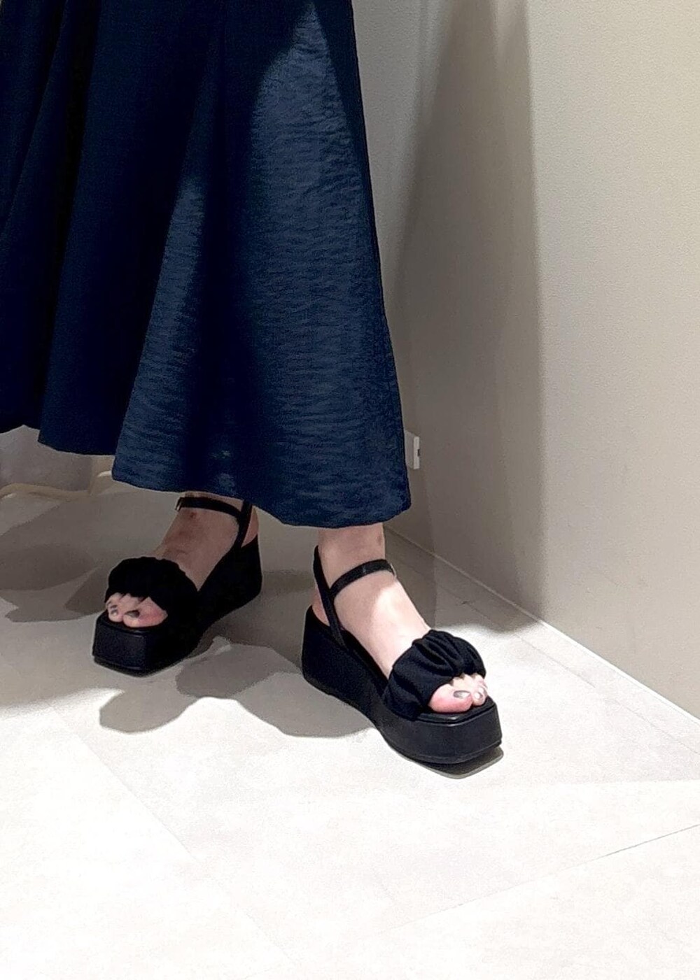 ホワイト系のハンドバッグ、ブルー系のスカート、グレー系のTシャツ/カットソーを着用したレディースの春コーディネートの7枚目の写真