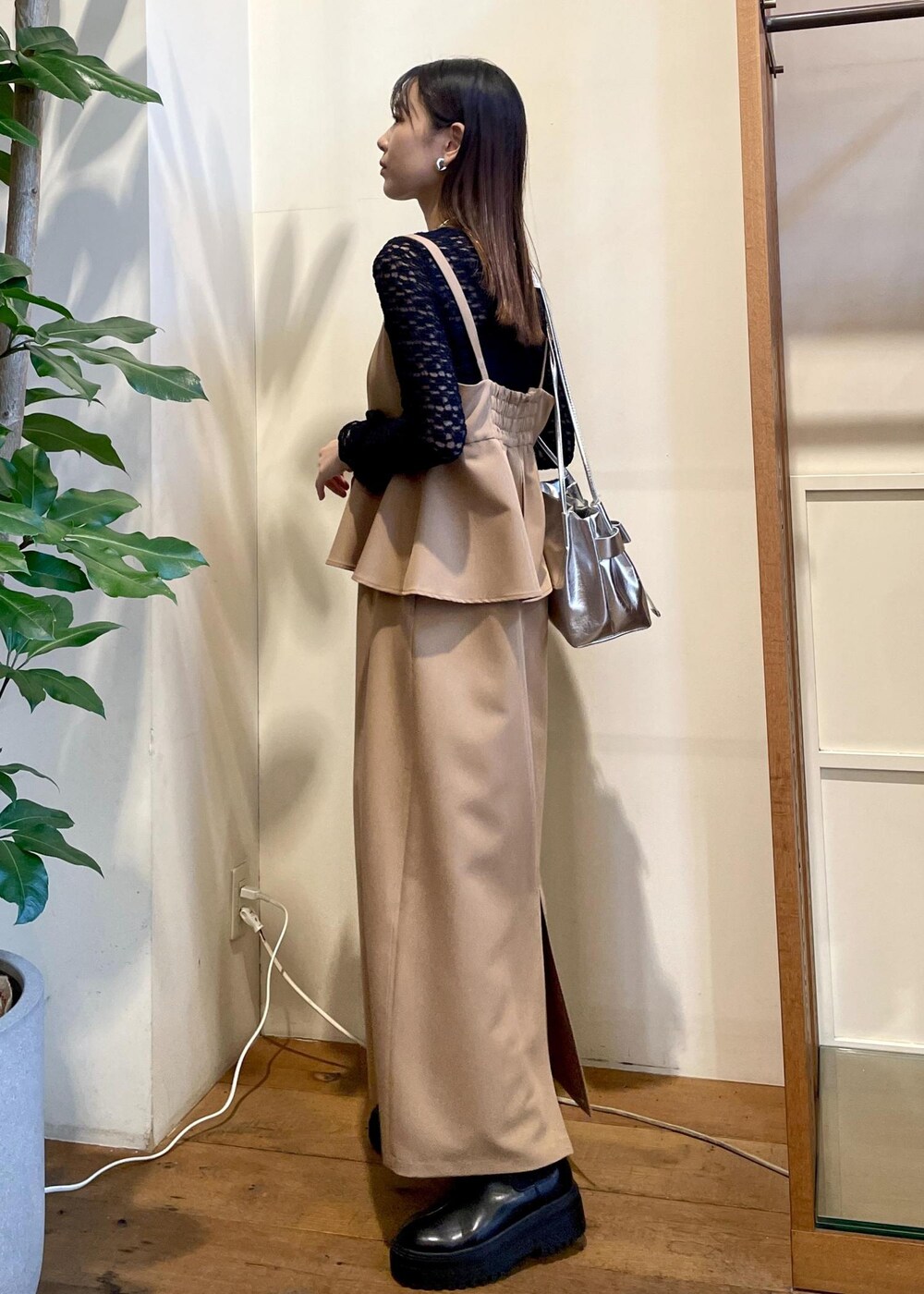 シルバー系のショルダーバッグ、ブラック系のブーツ、ブラック系のTシャツ/カットソーを着用したレディースの秋コーディネートの2枚目の写真