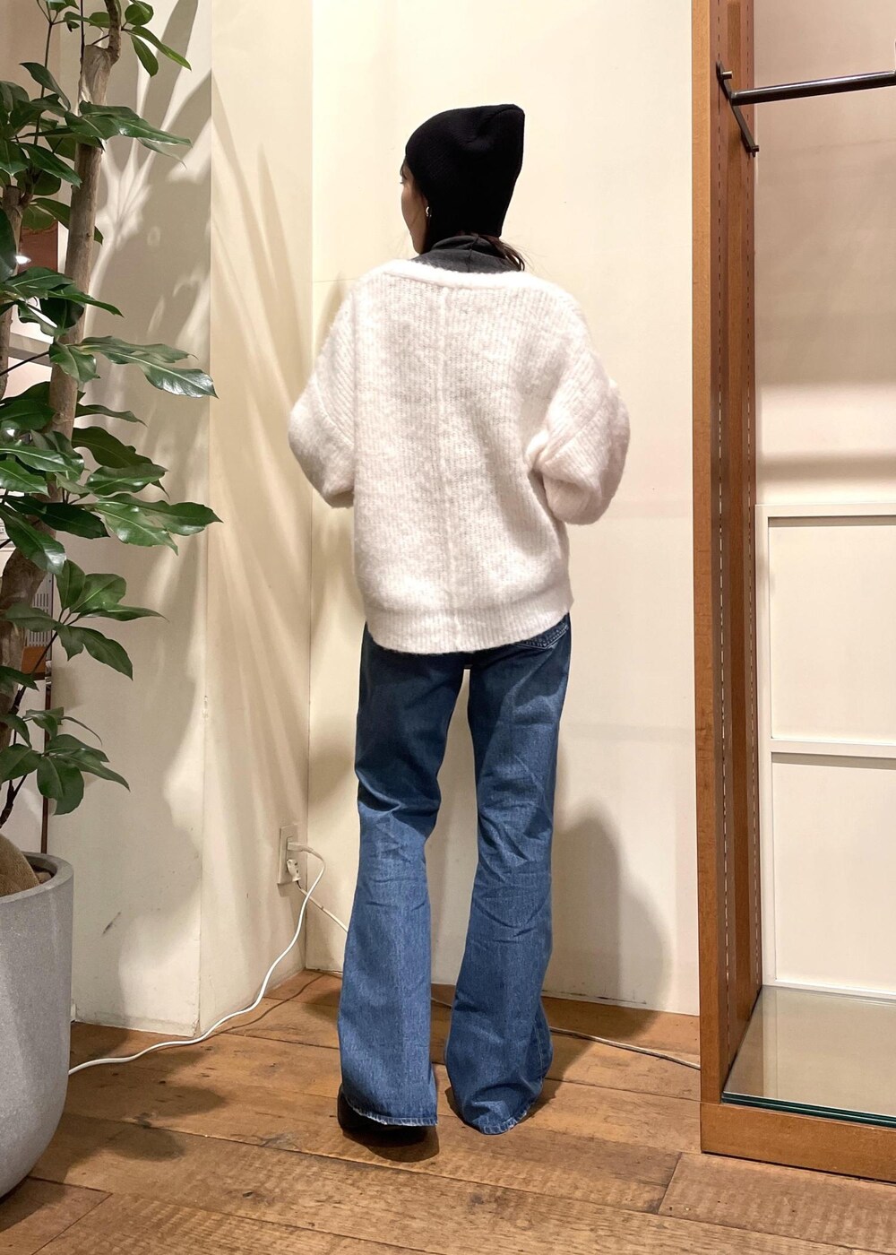 ブルー系のデニムパンツ、ブラック系のブーツ、ホワイト系のハンドバッグを着用したレディースの冬コーディネートの3枚目の写真