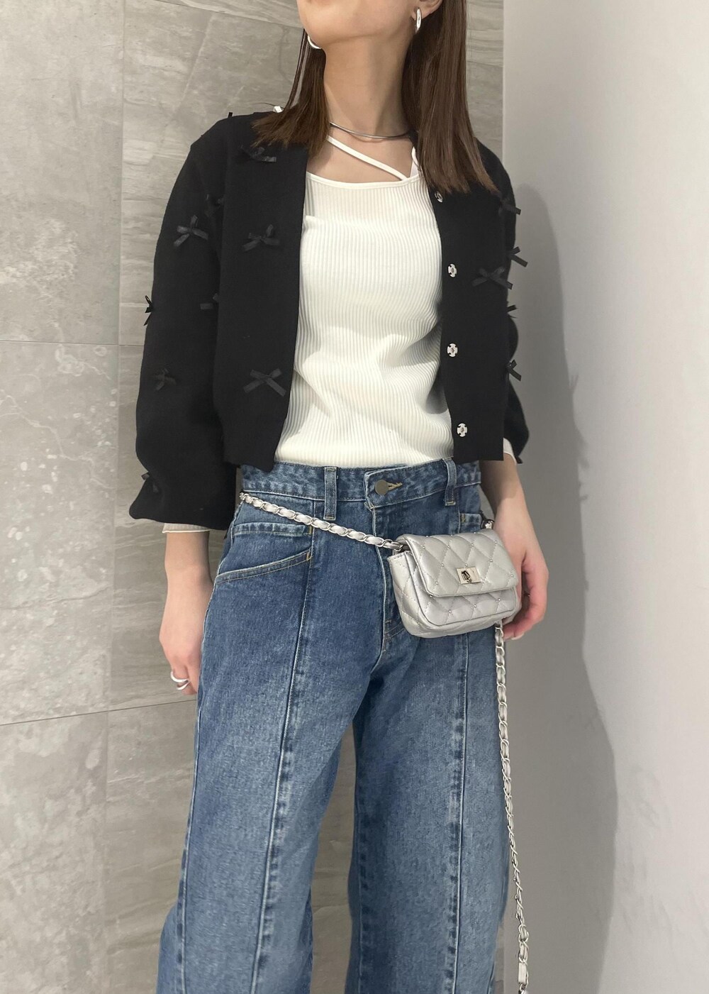 ホワイト系のブーツ、ブラック系のカーディガン/ボレロ、ホワイト系のTシャツ/カットソーを着用したレディースの冬コーディネートの2枚目の写真