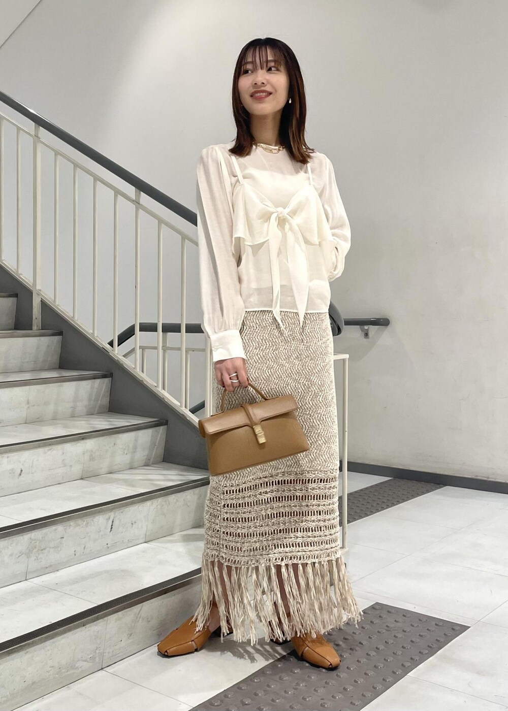 イエロー系のショルダーバッグ、イエロー系のサンダル、ホワイト系のシャツ/ブラウスを着用したレディースの春コーディネートの2枚目の写真