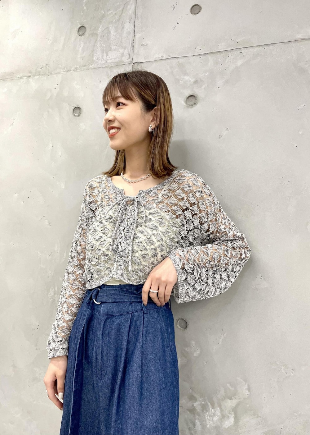 ホワイト系のサンダル、ブルー系のデニムパンツ、ブラック系のカーディガン/ボレロを着用したレディースの夏コーディネートの2枚目の写真