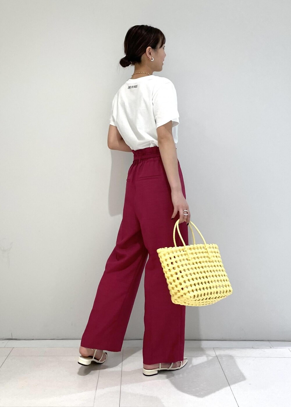 ピンク系のスラックス、ホワイト系のサンダル、ホワイト系のTシャツ/カットソーを着用したレディースの夏コーディネートの2枚目の写真