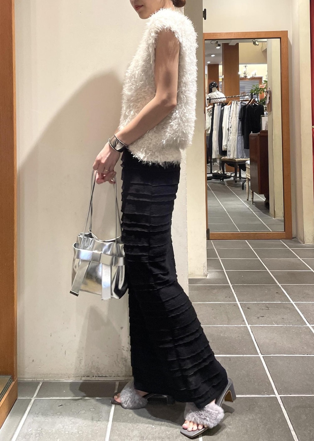 ブラック系のスカート、ブラック系のキャミソール、ホワイト系のベストを着用したレディースの夏コーディネートの2枚目の写真