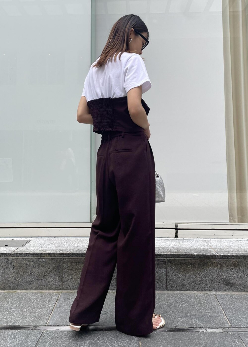 ホワイト系のサンダル、シルバー系のショルダーバッグ、ブラウン系のTシャツ/カットソーを着用したレディースの夏コーディネートの2枚目の写真