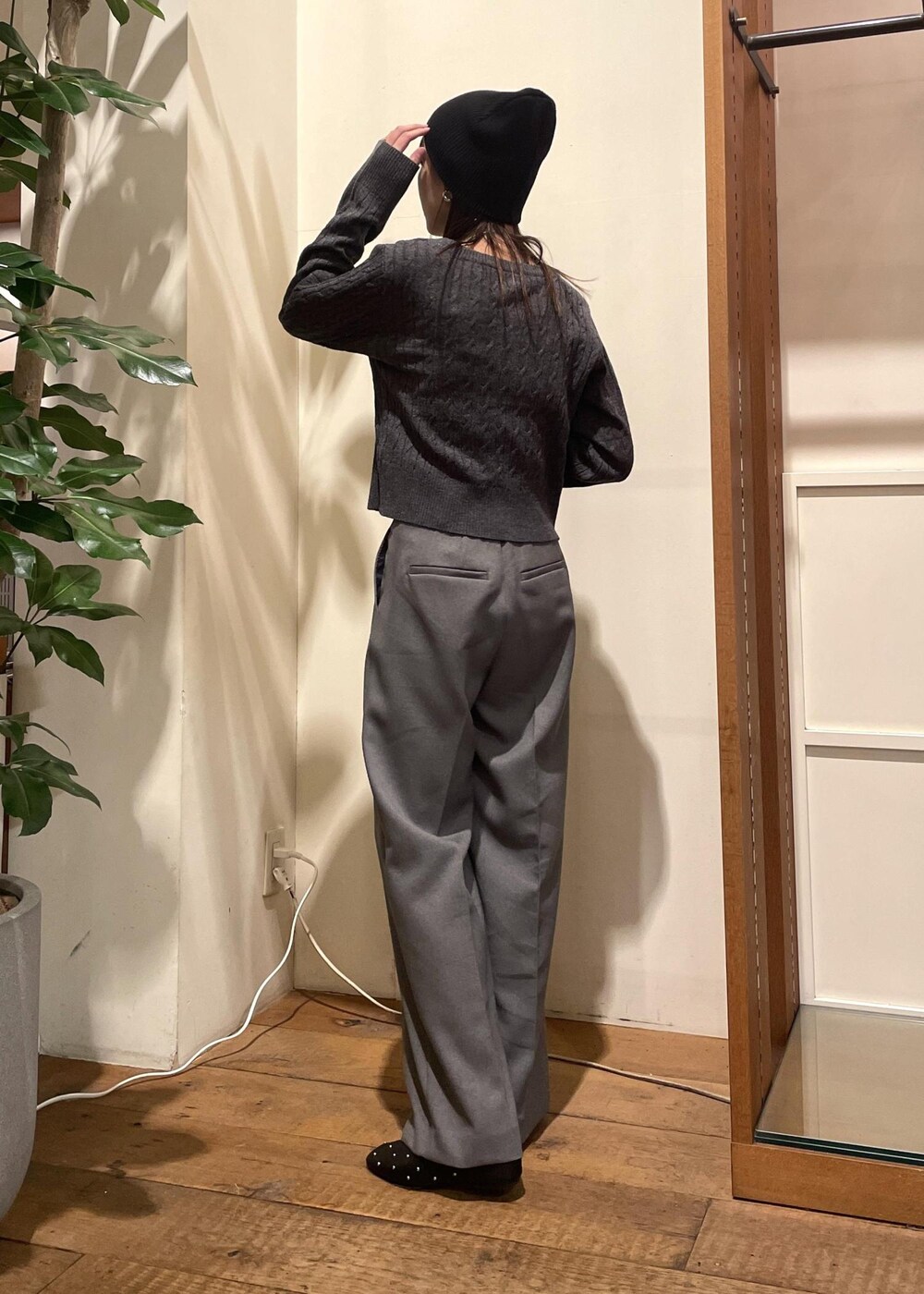 シルバー系のショルダーバッグ、ブラック系のバレエシューズ、グレー系のスラックスを着用したレディースの冬コーディネートの3枚目の写真