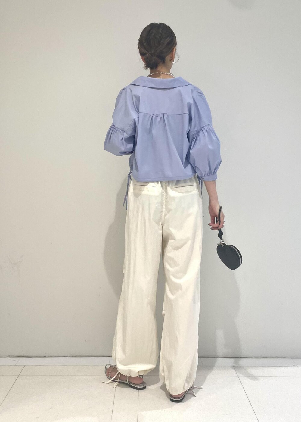 ブラック系のショルダーバッグ、ホワイト系のカーゴパンツ、ブルー系のシャツ/ブラウスを着用したレディースの夏コーディネートの2枚目の写真