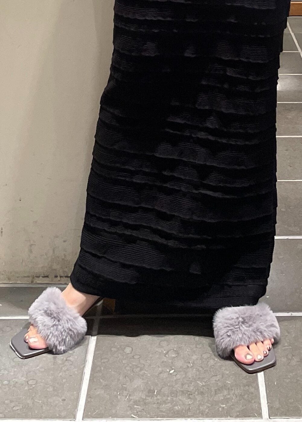 ブラック系のスカート、ブラック系のキャミソール、ホワイト系のベストを着用したレディースの夏コーディネートの6枚目の写真