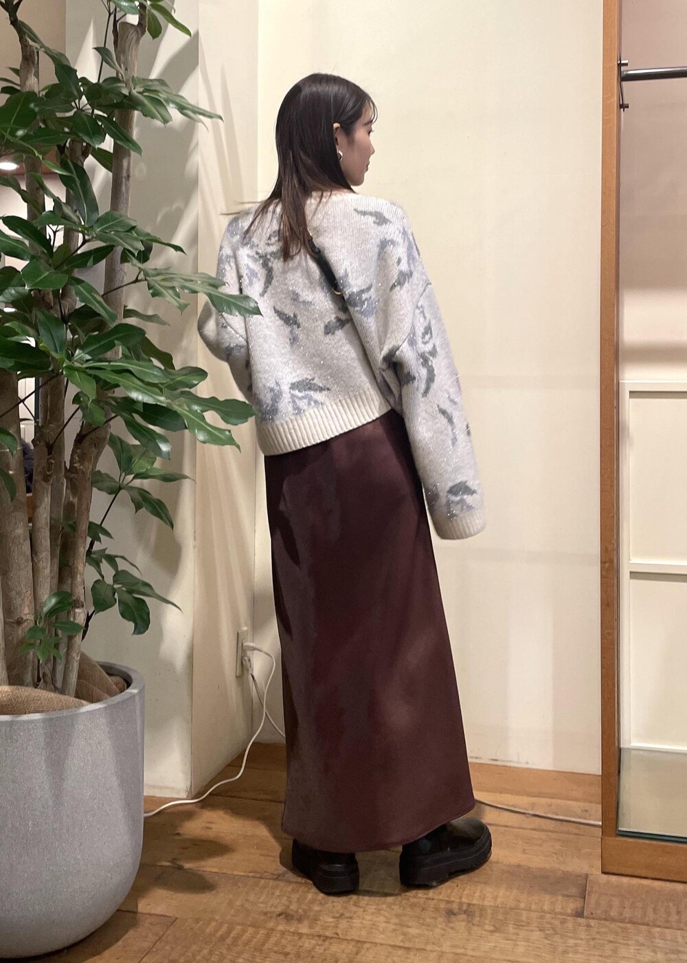 ブラック系のブーツ、グレー系のニット/セーター、ブラウン系のスカートを着用したレディースの冬コーディネートの3枚目の写真