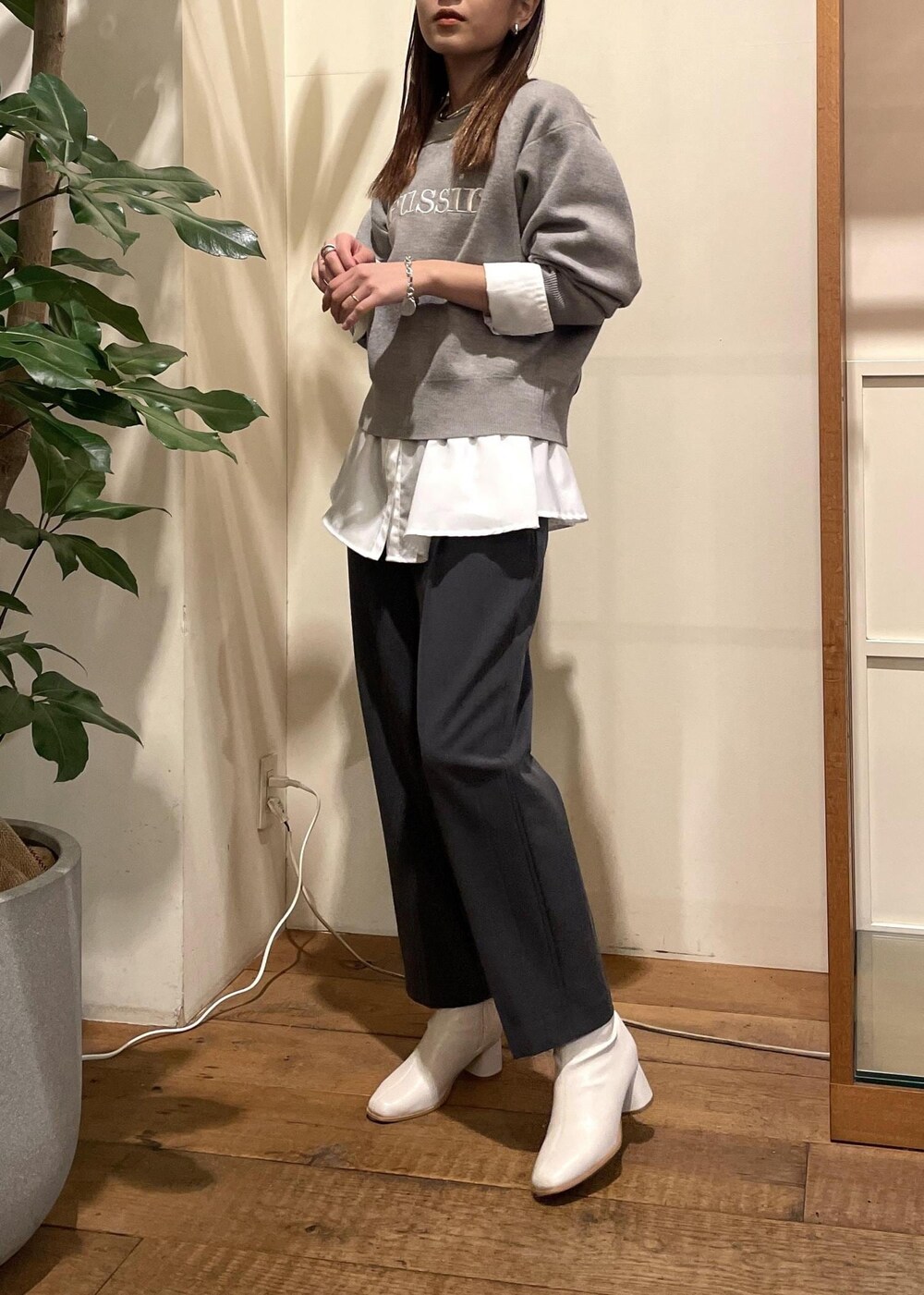 ホワイト系のブーツ、ホワイト系のシャツ/ブラウス、グレー系のニット/セーターを着用したレディースの秋コーディネートの2枚目の写真