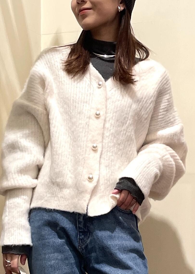 ブルー系のデニムパンツ、ブラック系のブーツ、ホワイト系のハンドバッグを着用したレディースの冬コーディネートの4枚目の写真