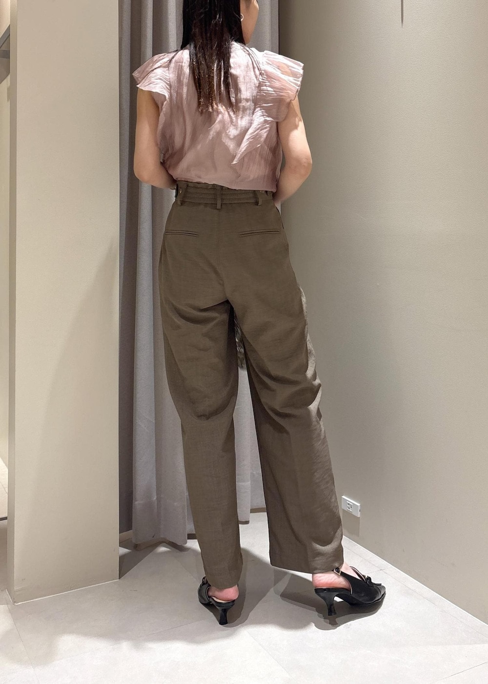 ブラック系のパンプス、グリーン系のスラックス、シルバー系のハンドバッグを着用したレディースの春コーディネートの3枚目の写真