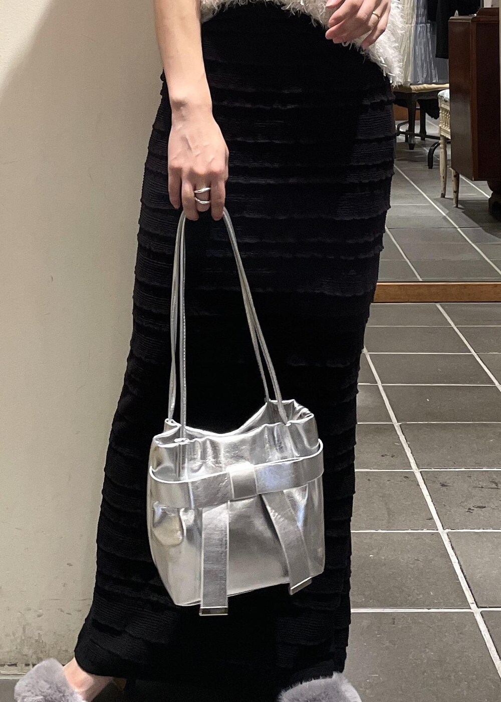 ブラック系のスカート、ブラック系のキャミソール、ホワイト系のベストを着用したレディースの夏コーディネートの5枚目の写真