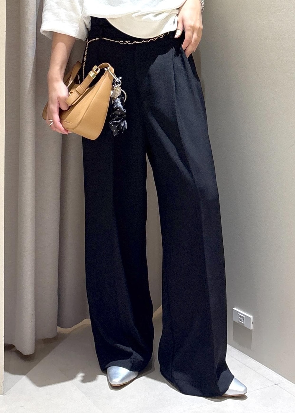 イエロー系のショルダーバッグ、ブラック系のその他パンツ、シルバー系のパンプスを着用したレディースの秋コーディネートの7枚目の写真